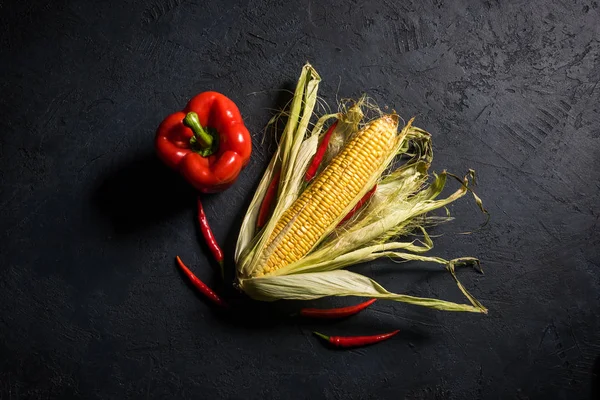 Siyah bir taş zemin üzerine biberli Mısır koçanı