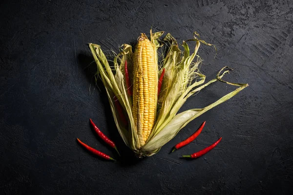 Siyah bir taş zemin üzerine biberli Mısır koçanı