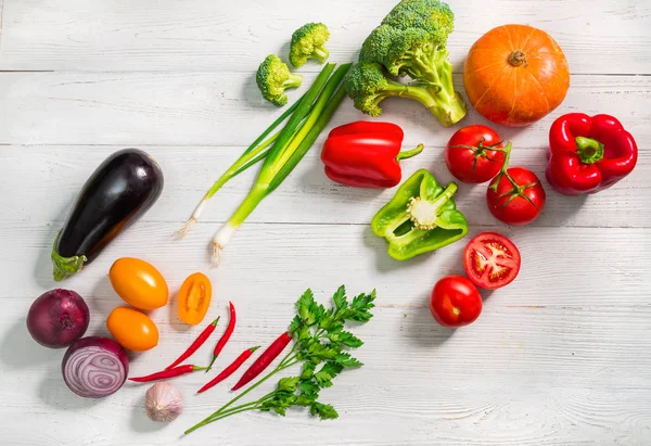 Beyaz ahşap zemin üzerinde sağlıklı taze sebze. Düz yatıyordu stili