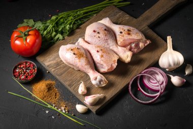 Siyah zemin ahşap bir gemide çiğ tavuk