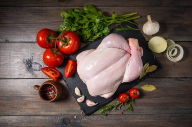 Ahşap bir arka plan üzerinde bir taş tahta üzerinde Çiğ tavuk