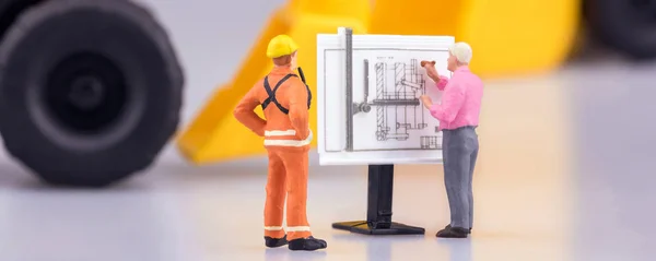 Miniature engineering people and architecture working on construction drawing in cover banner size. Elegant Design for industrial and construction concept.