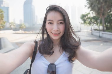 Güzel Asya kentsel şehir merkezindeki bir fotoğraf makinesinde selfies alarak turist kadın solo. Yaz aylarında tatil seyahat.
