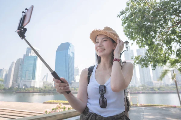 Hermosa mujer turista asiática tomando selfies en un smartphone en Hermosa mujer turista asiática tomando selfies en un smartphone en el centro urbano de la ciudad. Viajes de vacaciones en verano . — Foto de Stock