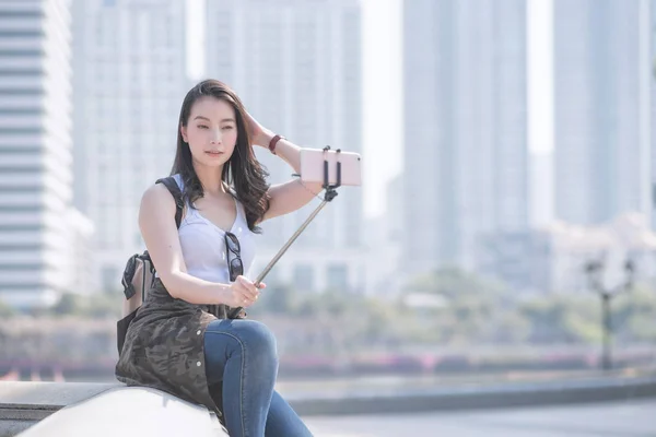 Hermosa mujer turista asiática tomando selfies en un teléfono inteligente en el centro urbano de la ciudad. Viajes de vacaciones en verano . — Foto de Stock