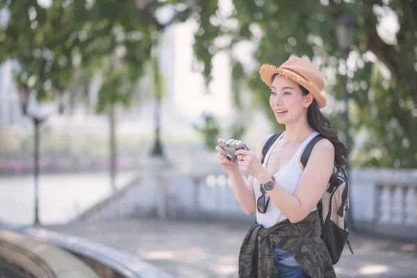 सुंदर एशियाई एकल पर्यटक महिला पर्यटन स्थल पर रेट्रो कैमरा द्वारा फोटो लेने का आनंद लेती है . — स्टॉक फ़ोटो, इमेज