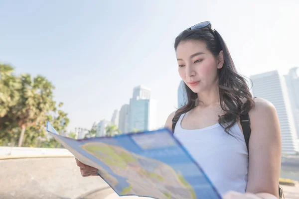 Hermosa mujer turista asiática mirando el mapa en busca de turistas punto de interés. Viajes de vacaciones en verano . — Foto de Stock