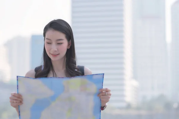 सुंदर एशियाई एकल पर्यटक महिला नक्शे को देख रही है पर्यटकों के दर्शनीय स्थल की तलाश में . — स्टॉक फ़ोटो, इमेज