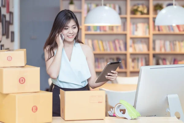 Young asian entrepreneur checking products stock at home office — 스톡 사진