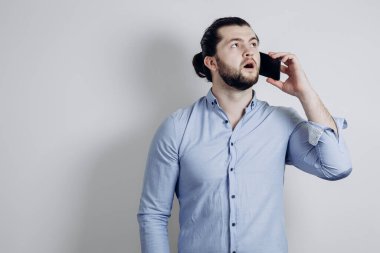 Uzun saçlı başarılı bir adam telefonda konuşuyor ve şaşırıyor..