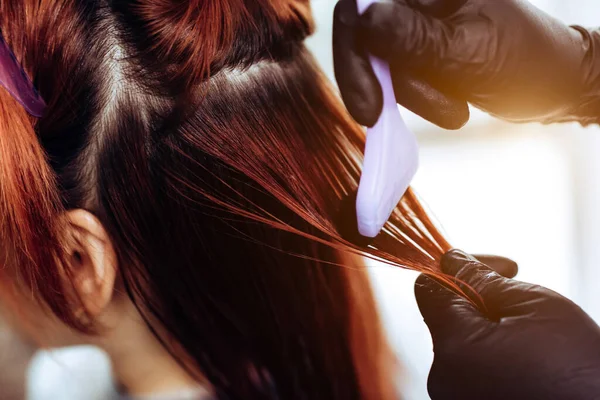 Fryzjer nakłada maskę na kobietę w salonie piękności. Procedura prostowania włosów botoksu i keratyny — Zdjęcie stockowe