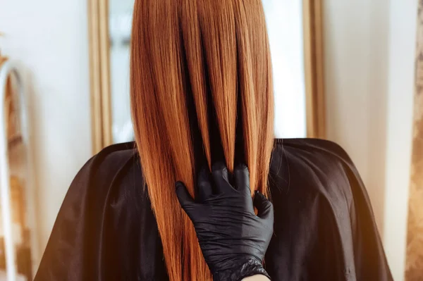 Cabeleireiro profissional escovar clientes lisos cabelo após procedimentos de beleza de cuidados com o cabelo. Visão traseira — Fotografia de Stock
