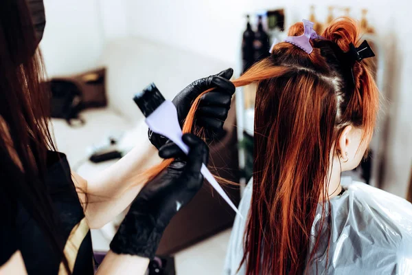 Fryzjer nakłada maskę na kobietę w salonie piękności. Procedura prostowania włosów botoksu i keratyny — Zdjęcie stockowe