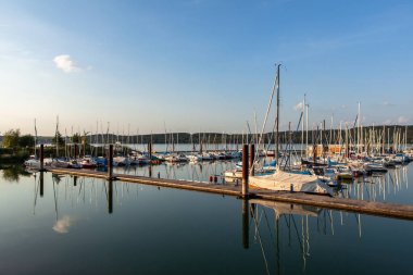 Boat station with yachts on Lake Brombach in the evening at sunset clipart