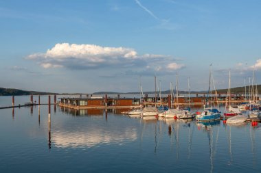 Boat station with yachts on Lake Brombach in the evening at sunset clipart