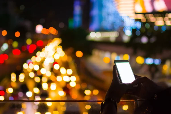 Merhaba gibi teknoloji kavramı renkli bokeh arka plan için smartphone parlak beyaz monitör ile oynamak adamın iki el kentte yaşam akşam ilerlemek..