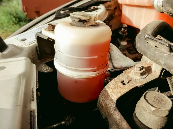 Man hand open power steering cap up for checking level of power steering fluid in the system, car maintenance service concept.