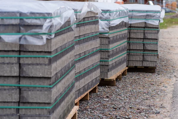 Pflastersteine Auf Mehreren Paletten Mit Folie Als Regenschutz Abgedeckt lizenzfreie Stockfotos