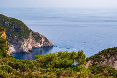Yunanistan 'ın Zakynthos kentinin kuzeybatısında küçük bir tekneyle kıyı ve mavi denize bakın.
