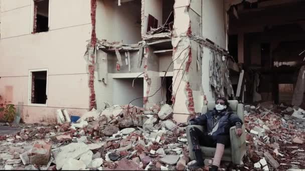 Postapocalypse, lonely young woman sits amid the destroyed buildings, ruins — Stock Video