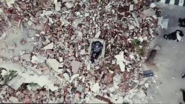 Postapocalypse, yalnız genç kadın yıkılan binalar, harabeler oturur.