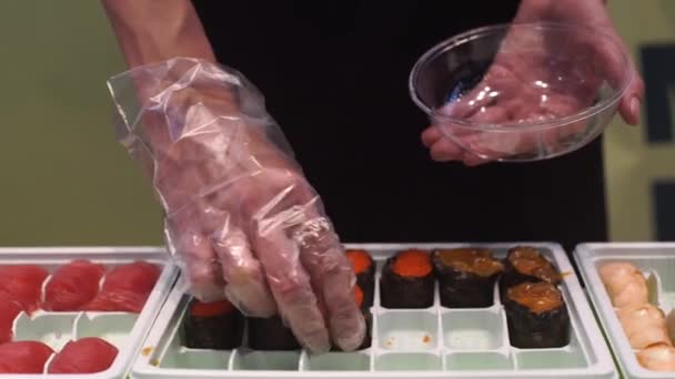 Uma mulher coloca rolos de sushi na placa — Vídeo de Stock