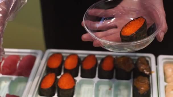 Žena umístí válce sushi do desky — Stock video