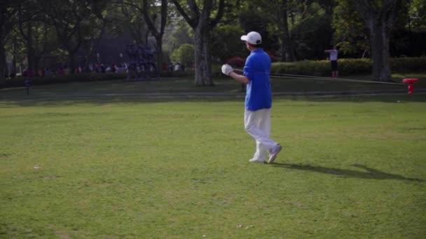 Un homme dans le parc tourne autour de lui sur la corde un tourbillon — Video