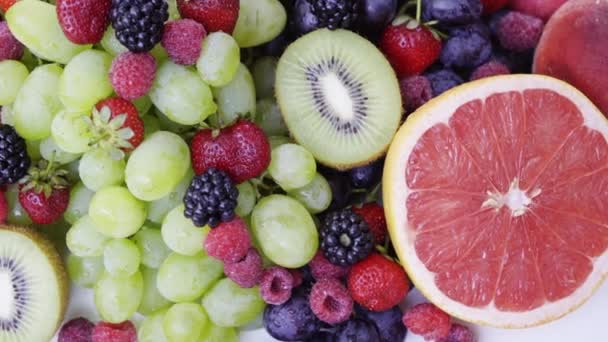 Hermosas bayas mixtas y frutas sobre fondo blanco. Cierre la comida saludable. 4K — Vídeos de Stock