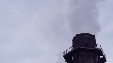 Büyük bir soba borusu üzerinde araştırma ve işleme tesisi sigara içiyor.