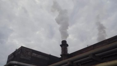 Büyük bir soba borusu üzerinde araştırma ve işleme tesisi sigara içiyor.