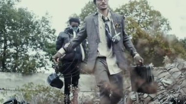 Postapocalypse, yalnız genç kadın çöp dökümü, yıkılan binalar arasında yürüyor.
