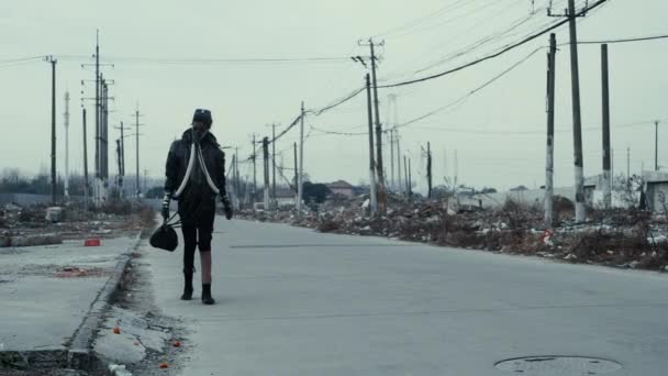 Postapocalypse, osamělá mladá žena chodí uprostřed odpadků skládky a abondoned město — Stock video