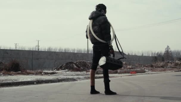Postapokalypse, einsame junge Frau spaziert zwischen Müllhalde und verlassener Stadt — Stockvideo