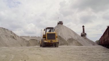 Büyük bir ekskavatör ezilmiş taş tren arabaya yüklemek için yardımcı olur