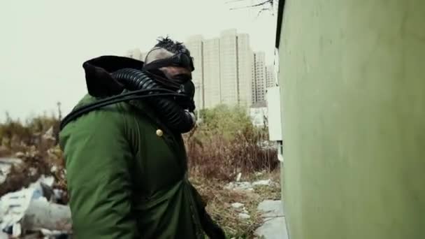 Postapocalypse, одинокий человек ходит среди свалки мусора и заброшенного города — стоковое видео