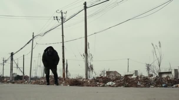 Pós-apocalipse, homem solitário caminha em meio a lixeira e cidade abandonada — Vídeo de Stock