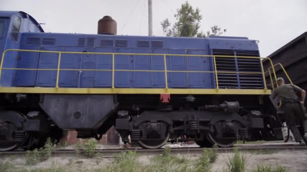 O mecânico verifica um comboio. Reparação do sistema de quebra da locomotiva . — Vídeo de Stock