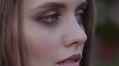 Kızıl saçlı olumlu harika kız kamera 4 k yakın çekim resme bakıyor.