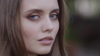 Kızıl saçlı olumlu harika kız kamera 4 k yakın çekim resme bakıyor.