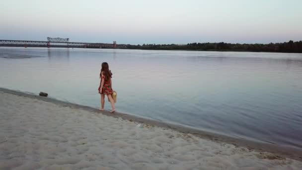 Atractiva joven mujer está caminando sobre una arena de la orilla del río — Vídeo de stock