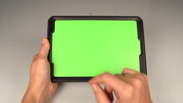 A woman holds a tablet PC with a green screen for your own custom content. — Stock Video