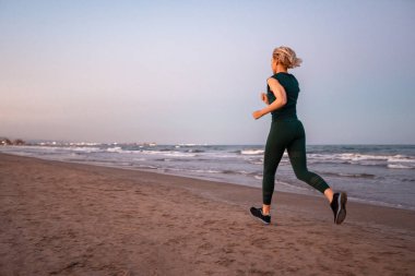 Bir deniz plajı tarafında çalışan kısa sarı saçlı Güzel insanlar Fitness kadın . Spor ve Sağlıklı Yaşam Konsepti