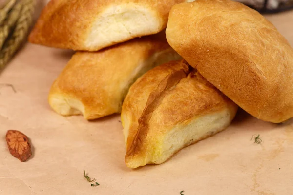 Traditional Russian pies with vegetarian and meat fillings are served on a craft paper.