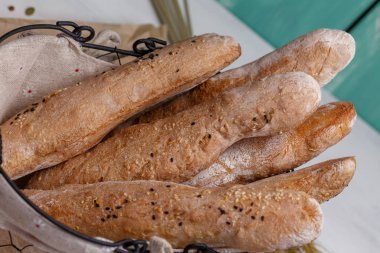 Susam ve fındık ile ev yapımı gizlemek baget. Ekmek sepetindeki bir zanaatta çavdar hamuru. Akşam yemeği için çavdar ekmeği. Taze kokulu lezzetli ev yapımı hamur işleri.