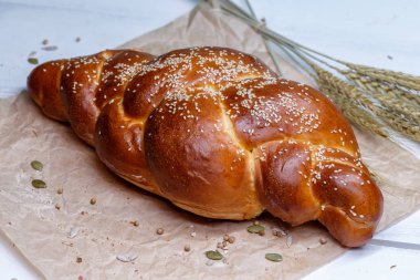 Ev yapımı tatlı ekmek pigtail. El işi bir kağıtta çay için ekmek. Akşam yemeği için ekmek. Taze kokulu lezzetli ev yapımı hamur işleri.