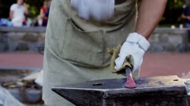 Parlayan sıcak bıçak bladesmith tarafından tutulan ağır bir çekiç tarafından vuruldu. Tanınmayan bir zanaatkârın bıçak dövmesinin sinematik detaylı fotoğrafı. Parlak turuncu çelik sahte oluyor.