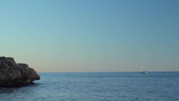深い青い海水の背景に日光の下で水の道を残して海の遠くに船 地平線上の船 ボート 晴れた夏の日 澄んだ青空 風と波 — ストック動画