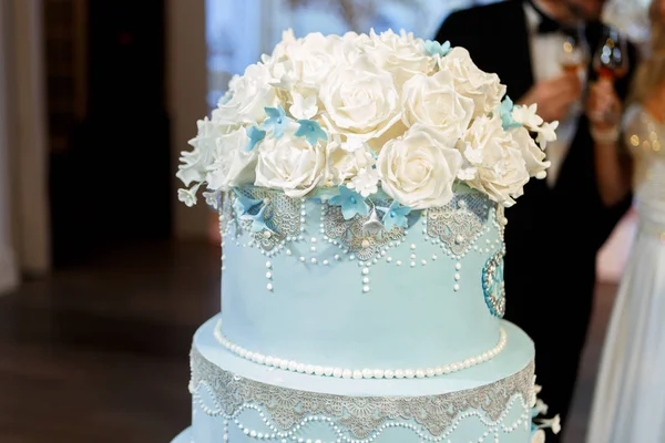 big blue wedding cake decorated with flowers