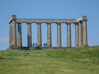 Edinburgh / İskoçya / İngiltere - 04 / 20 / 2014: İskoçya Ulusal Anıtı 'nın Edinburgh' daki Calton Hill 'de manzarası, etrafındaki çimenler ve insanların tadını çıkarmasıyla